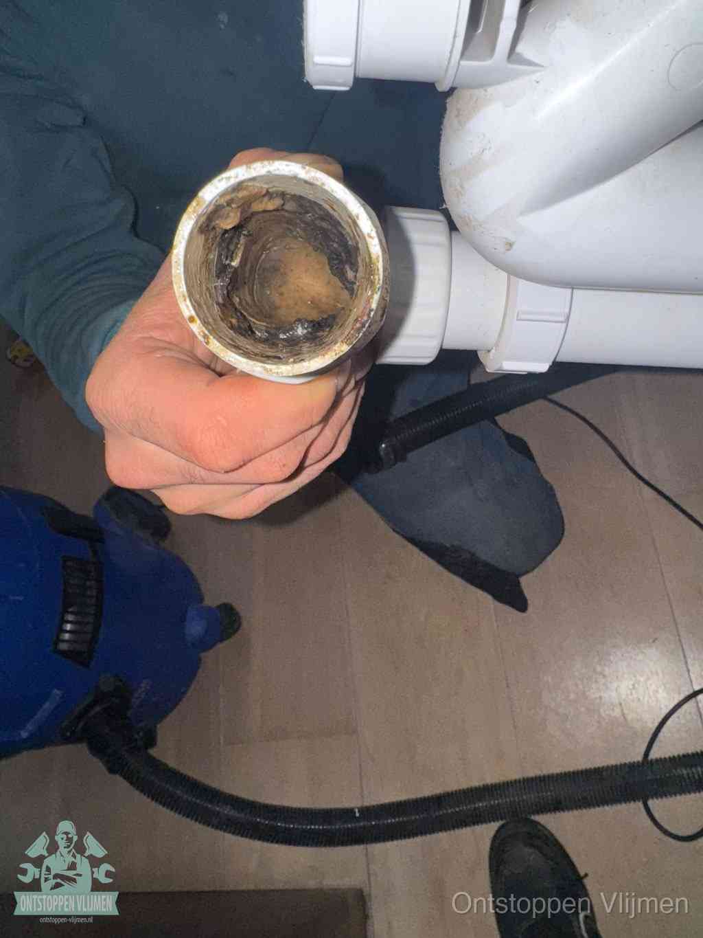 Een losgekoppeld afvoerbuisstuk dat van binnen volledig is dichtgeslibd, het gevolg van een verstopping te lang laten zitten in Vlijmen