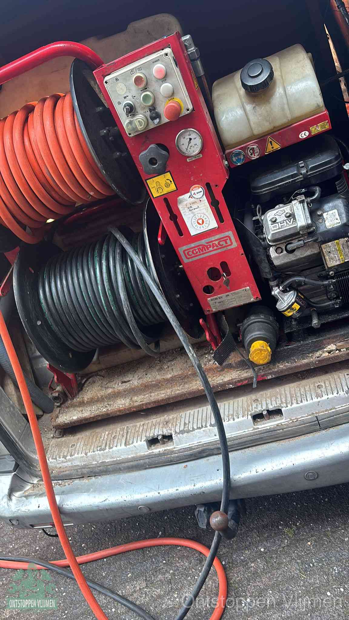 Een rood hogedruk-rioolreinigingstoestel in de laadbak van de bedrijfsbus, apparatuur voor een hardnekkige afvoerverstopping in Vlijmen