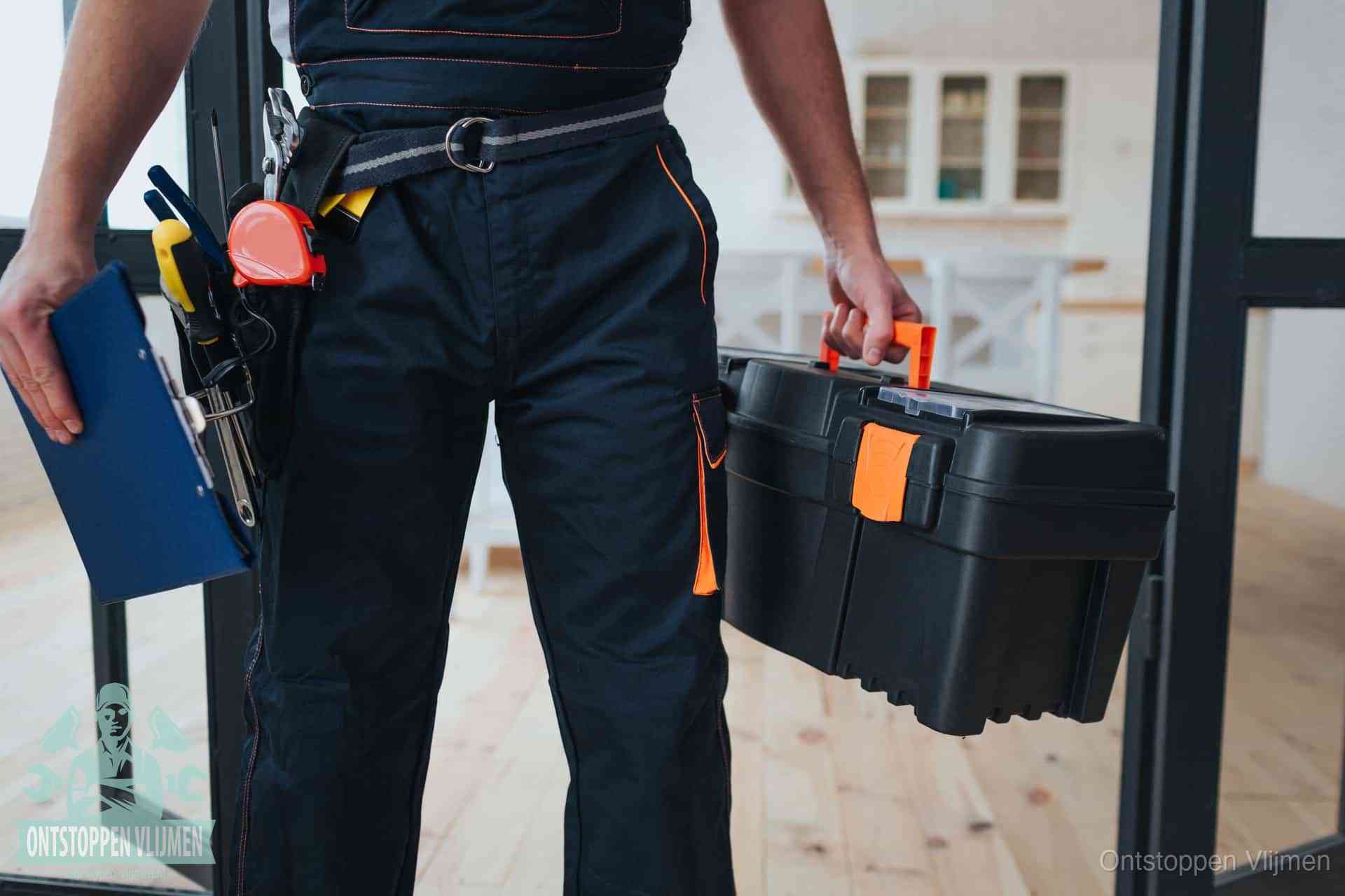 Een monteur met gereedschapsriem en klembord, klaar om een transparante prijs voor het wc ontstoppen in Vlijmen te geven