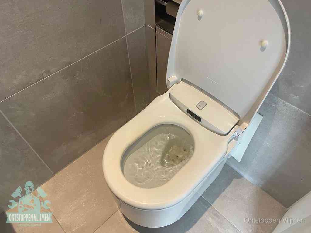 Een toiletpot vol troebel water met drijvend papier en restanten, de meest voorkomende oorzaak van een verstopte wc in Vlijmen