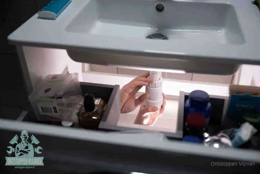 Een pompfles met zeep boven een wastafel in de toiletruimte, de warm water en afwasmiddel-methode om de wc te ontstoppen in Vlijmen